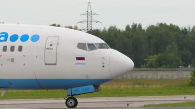 NOVOSIBIRSK, RUSSIAN FEDERATION - JULY 15, 2022: Front of the aircraft, cockpit. Boeing 737 of Pobeda Air taxiing on the runway at Tolmachevo airport,. Tourism and travel concept