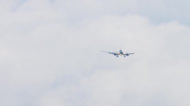 Jet airplane released landing gear. Passenger airliner landing down, front view, haze from hot weather