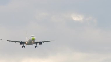 Front view of an airliner descending for landing. Footage of a commercial aircraft flying. Tourism and travel concept