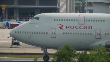 PHUKET, THAILAND - NOVEMBER 30, 2016: Side view, passenger wide-body double-deck Boeing 747 of Rossiya airlines acceleration to take off at Phuket airport. Tourism and travel concept