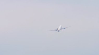 Footage unrecognizable jet plane flies away, gaining altitude, rear view long shot. Tourism and travel concept