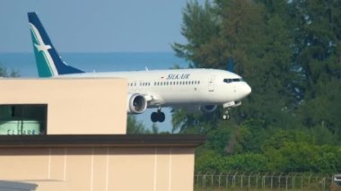 PHUKET, THAILAND - NOVEMBER 26, 2016: Boeing 737 of SilkAir landing at Phuket Airport, side view. Landing gear touching the airport runway. Tourism and travel concept