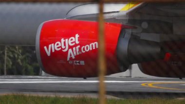 PHUKET, THAILAND - NOVEMBER 30, 2016: Footage of VietJet aircraft engine close-up shot. Commercial jet plane on runway at Phuket airport. Tourism and travel concept