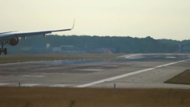 Rear view, unrecognizable jet plane silhouette landing and braking. Smoke from landing gear touching the runway