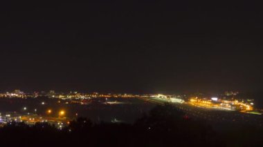 Footage of traffic at night airport, timelapse. Airfield and runway with landing lights glow at night