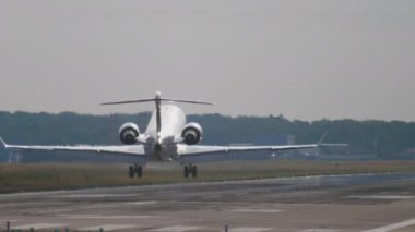 Jet passenger plane landing, touching and braking. Smoke from landing gear touching the runway