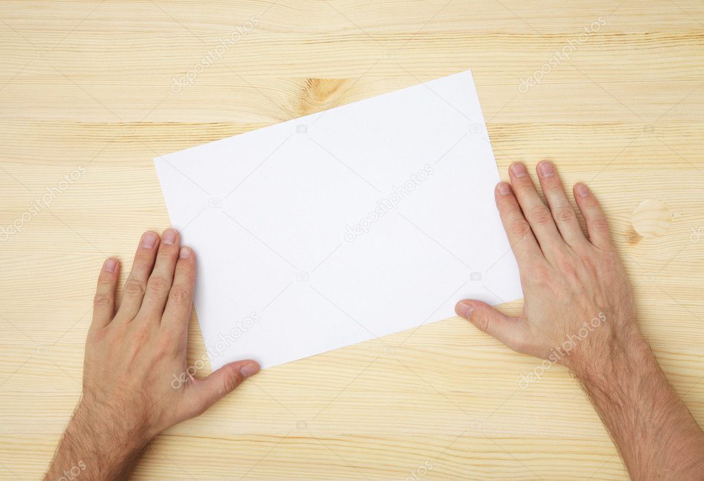 Human hand holds a blank paper