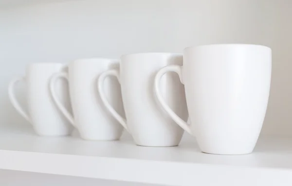 White cups on the shelf — Stock Photo, Image