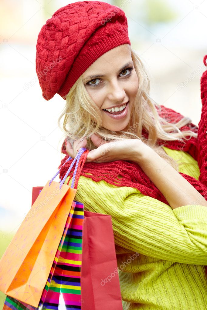 Smiling girl in autumn colours with shopping bags