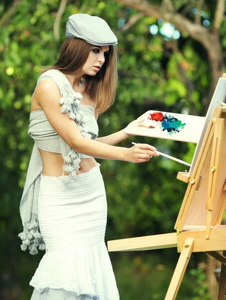 Fashion woman is painting. Open air session. — Stock Photo, Image