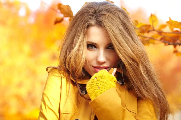 Schöne elegante Frau steht im Herbst in einem Park — Stockfoto