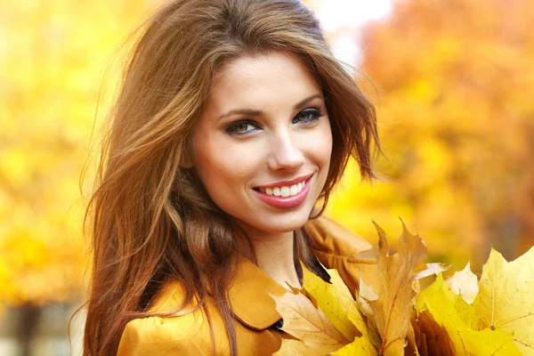 Hermosa mujer elegante de pie en un parque en otoño Imagen De Stock