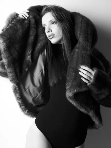 BW portrait of stylish woman in fur against grey background — Stock Photo, Image