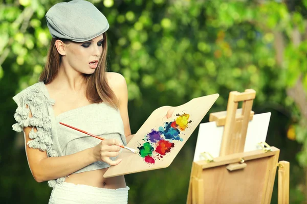 Ung kvinne maler landskap i friluft – stockfoto