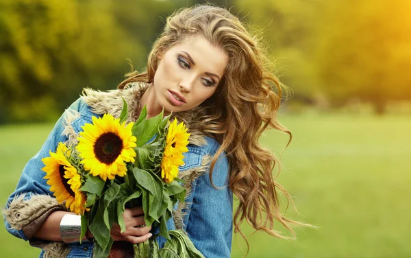 Kobieta moda młody z bukietem słoneczników w polu — Zdjęcie stockowe