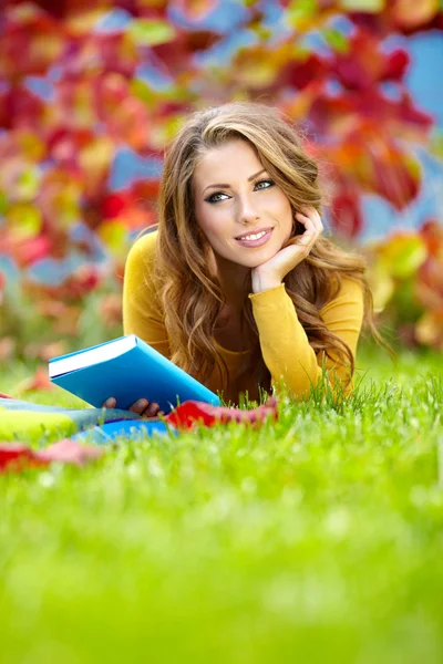 Menina bonita com livro no parque de outono — Fotografia de Stock