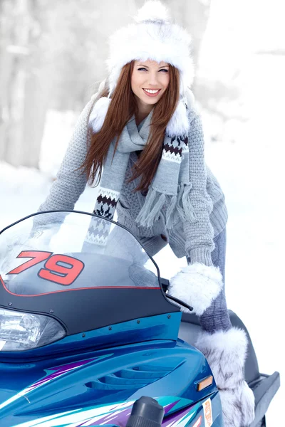 Lachende jonge vrouw een sneeuwscooter rijden — Stockfoto