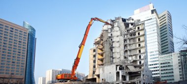 Yıkım vinçleriyle kısmen yıkılmış ofis binası.