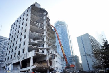 Yıkım vinçleriyle kısmen yıkılmış ofis binası.