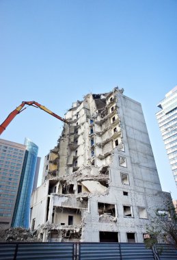 Yıkım vinçleriyle kısmen yıkılmış ofis binası.