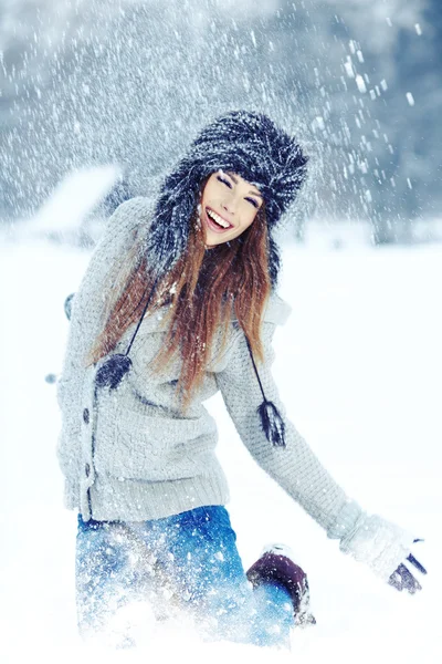 女の子は公園で雪と遊ぶ — ストック写真