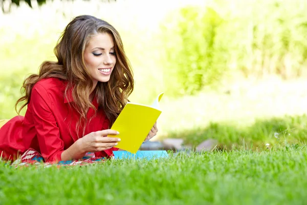 Belle fille avec livre dans le parc de printemps — Photo