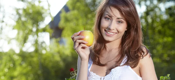 Apple woman. Very beautiful model eating red apple in the park. — Stock Photo, Image