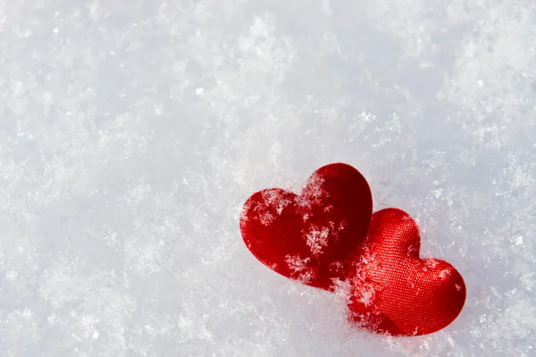Два червоних заморожених серця на снігу — стокове фото