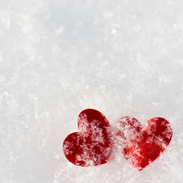 Dois corações vermelhos congelados na neve — Fotografia de Stock