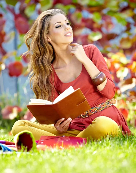 Belle fille avec livre dans le parc de printemps — Photo