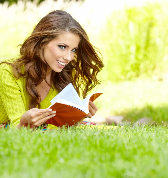 Belle fille avec livre dans le parc de printemps — Photo