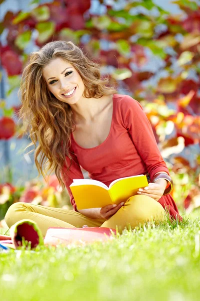Vacker flicka med bok i parken våren — Stockfoto