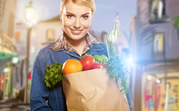 Portrait of a middle aged woman carrying a purchase at a crowded — Stock Photo, Image