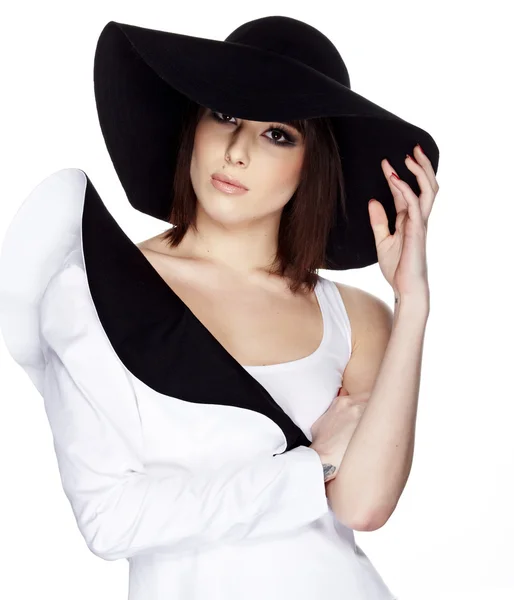 Fashionable woman in a hat posing in light background — Stock Photo, Image