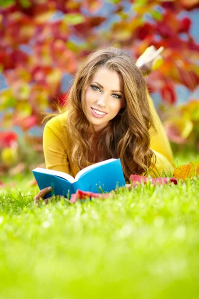 Belle fille avec livre dans le parc de printemps — Photo