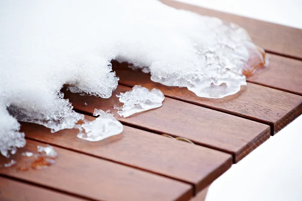 Glace de fonte cassée sur le pont peint en rouge en bois — Photo