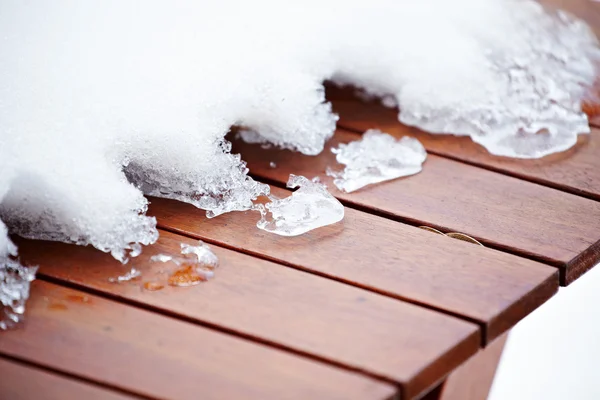 Glace de fonte cassée sur le pont peint en rouge en bois — Photo