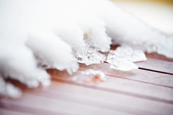 Glace de fonte cassée sur le pont peint en rouge en bois — Photo