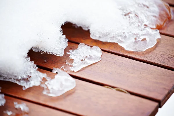 Glace de fonte cassée sur le pont peint en rouge en bois — Photo