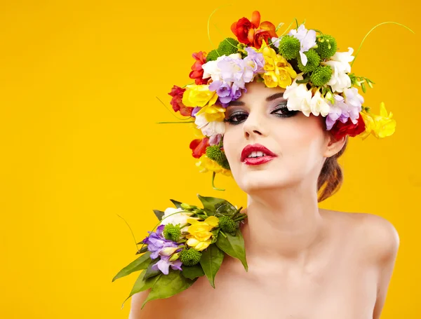 Vrouw met kapsel en bloem. geïsoleerd op geel — Stockfoto