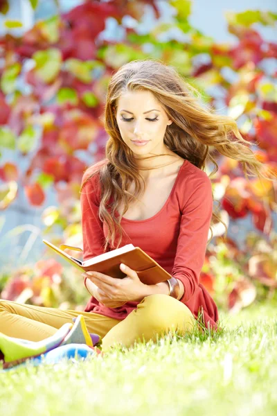 Vacker flicka med bok i parken — Stockfoto