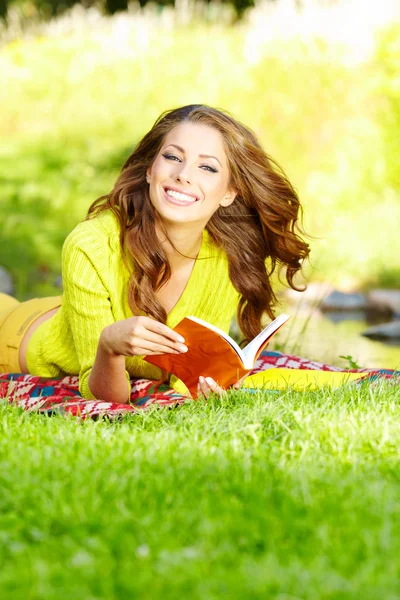 Mooi meisje met boek in park — Stockfoto