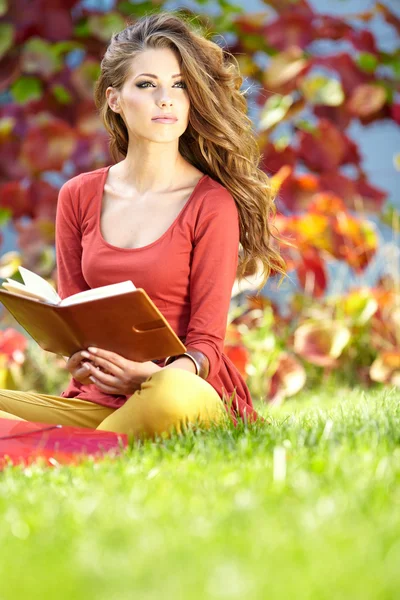 Menina bonita com livro no parque — Fotografia de Stock