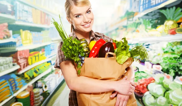 Frau kauft Obst und Gemüse in Warenabteilung ein Stockbild