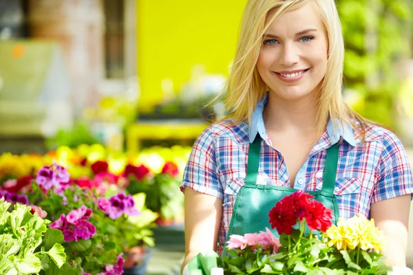 Donna che tiene una scatola di fiori mentre sorride — Foto Stock