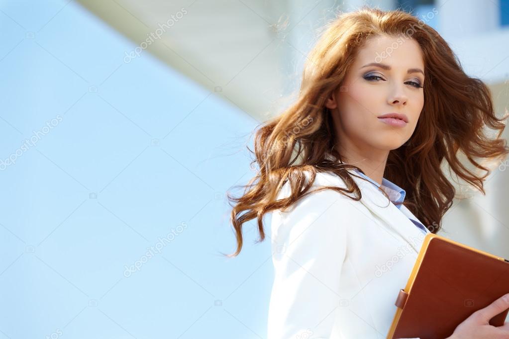 Beautiful young businesswoman among the skyscrapers