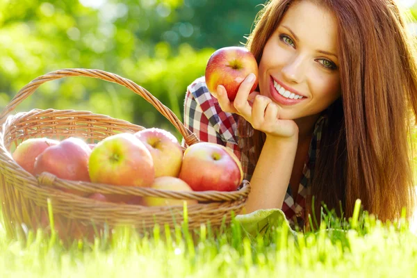 Mooie vrouw in de tuin met appels — Stockfoto
