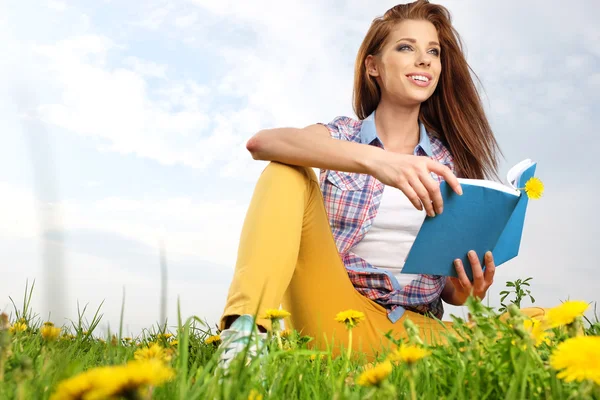 Schönes Mädchen mit Buch auf Gras — Stockfoto