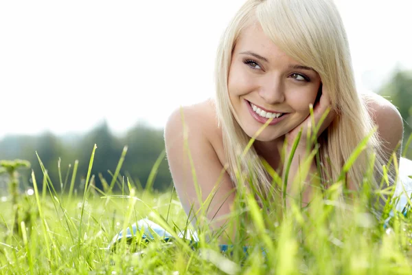 Mooie jonge vrouw op veld in de zomer — Stockfoto