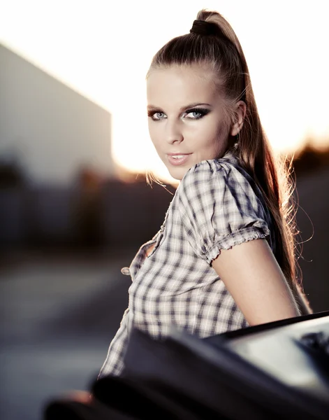 Piękne blond modelu siedzi na starego samochodu na noc strzał — Zdjęcie stockowe